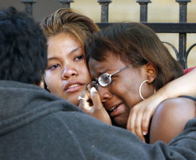 
 Elwina Davis, left, hugs her cousin Jasmin Lamb at the scene of a fire that killed six children early Sunday. 
 (Associated Press / The Spokesman-Review)