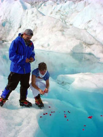 
Ken Rose, left, and Dagmar Johnson  float rose pedals into a glacial stream on the Mendenhall Glacier on their wedding day. The couple spent their wedding night in a tent on the glacier and saw the northern lights.
 (Associated Press / The Spokesman-Review)
