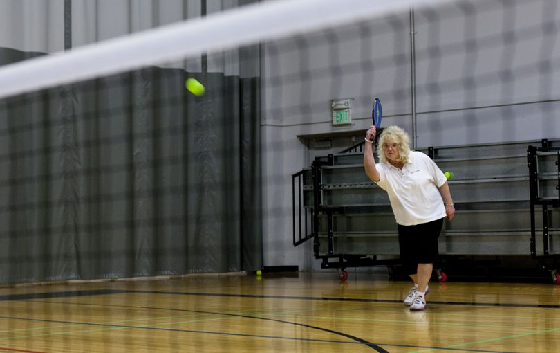 Sunny Lynne Gray's serves the pickleball wiffleball and it just makes it over the short net at the HUB Sport's Center. The group plays four times a week at the Liberty Lake athletic facility.  (Nicole Hensley)