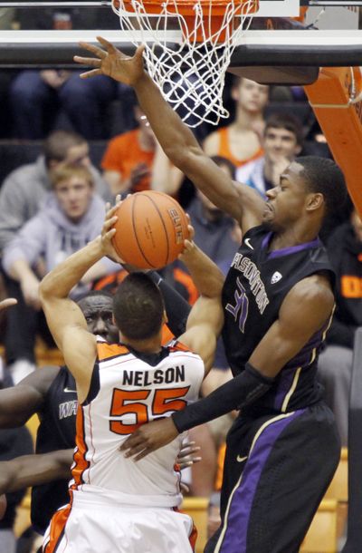 Washington’s Terrence Ross thwarts shot by Oregon State’s Roberto Nelson. (Associated Press)