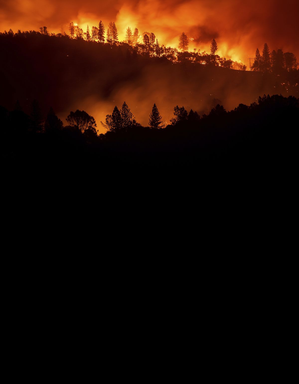 The Camp Fire  rages along a ridgetop near Big Bend, Calif., on Saturday. It has burned more than 6,000 structures. (Noah Berger / Associated Press)