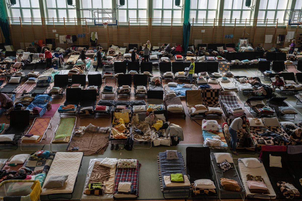 People who fled the war in Ukraine rest inside an indoor sports stadium being used as a refugee center on Tuesday in the village of Medyka, a border crossing between Poland and Ukraine.  (Petros Giannakouris)