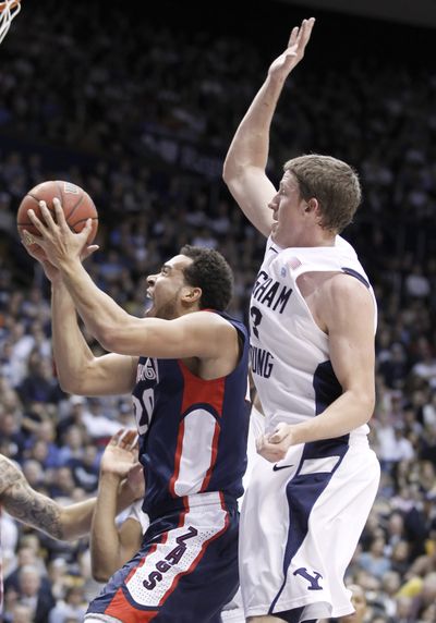 GU’s Elias Harris, left, shoots past BYU’s Brock Zylstra during first half of the Bulldogs’ 83-73 defeat. (Associated Press)
