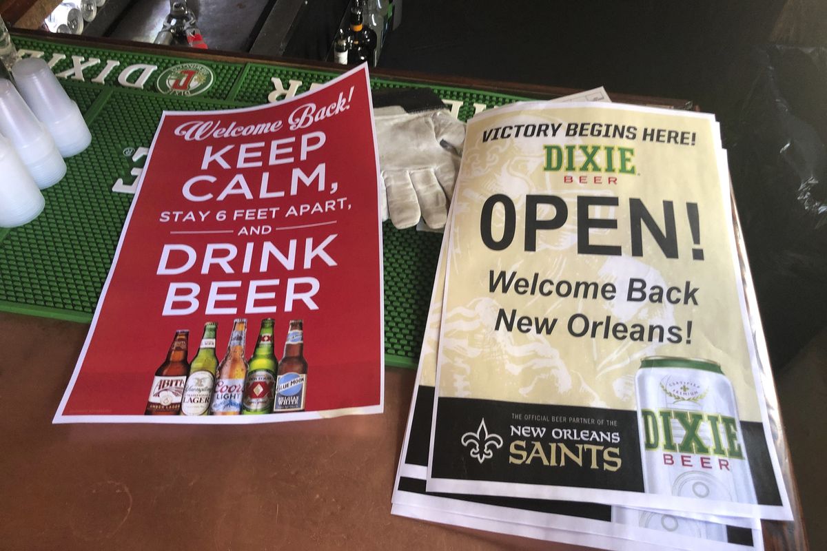 In this Friday, June 12, 2020 photo, stacks of signs for welcoming back patrons sit on the bar at Lafitte