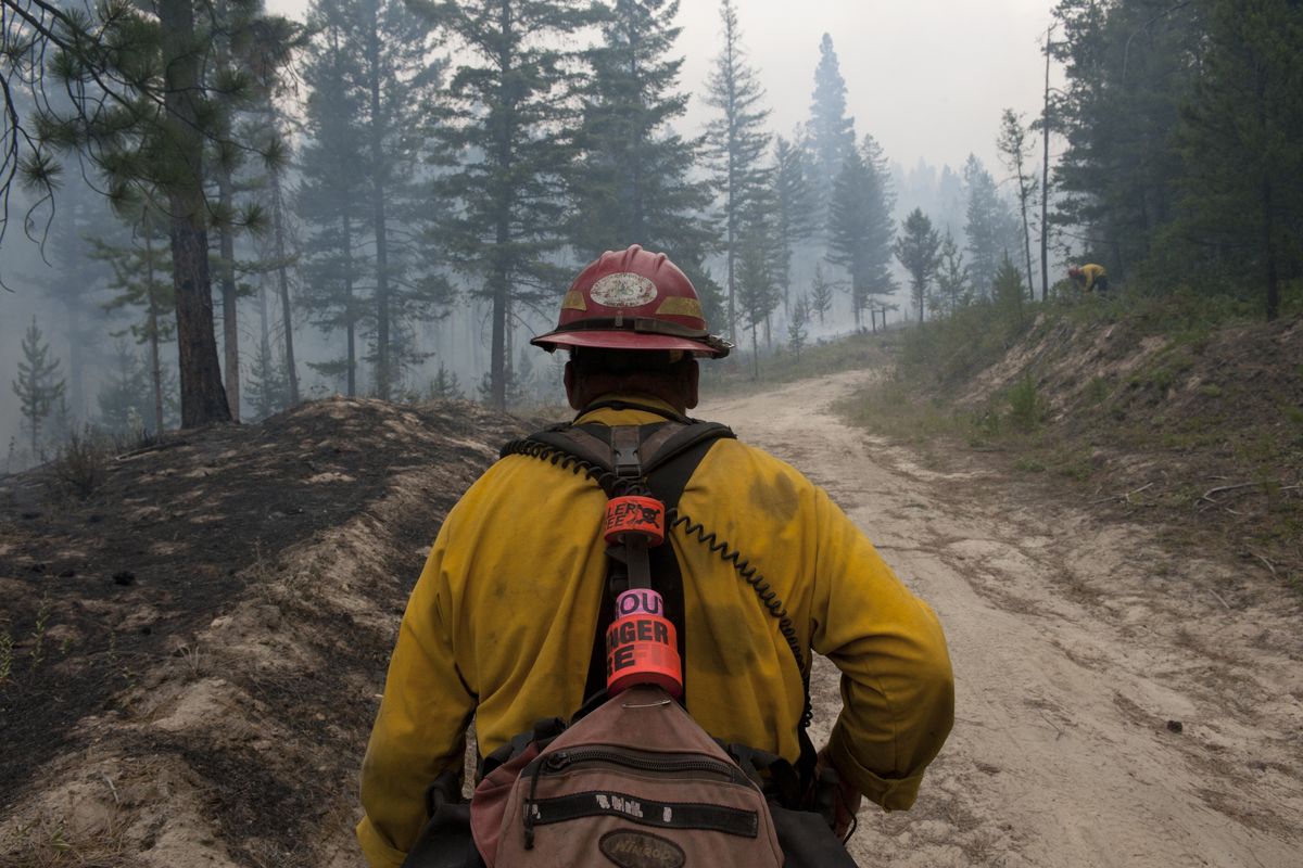 Mike Cade, with Oregon’s Woodpecker Fire Crew, heads out to check on his firefighters as they work Saturday near Highway 20 near Twisp, Washington. (Tyler Tjomsland)