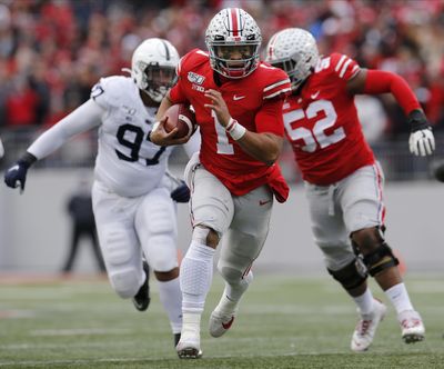 Ohio State quarterback Justin Fields, center, runs for a first down against Penn State during the first half of an NCAA college football game Saturday, Nov. 23, 2019, in Columbus, Ohio. (Jay LaPrete / Associated Press)