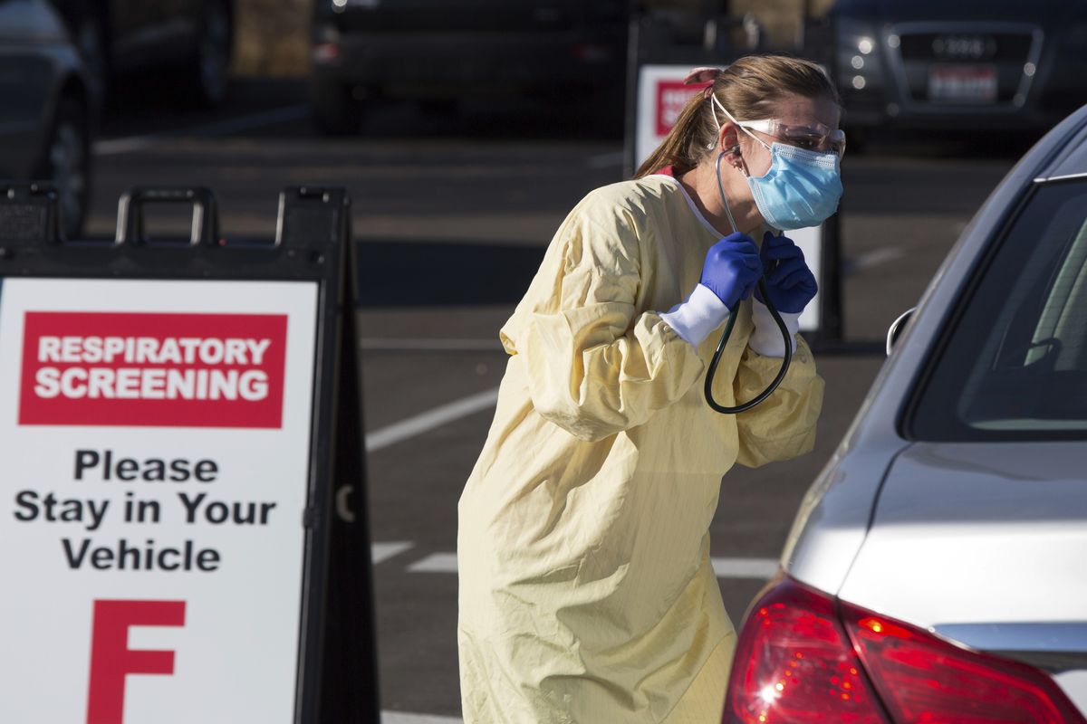 Physician assistant Nicole Thomas conducts a COVID-19 screening Nov. 24 in the parking lot at Primary Health Medical Group’s clinic in Boise.  (Otto Kitsinger)