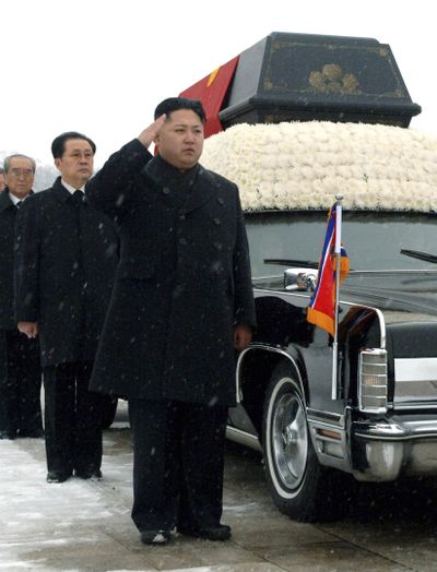 North Korea's next leader, Kim Jong Un, center, salutes beside the hearse carrying the body of his late father and North Korean leader Kim Jong Il during the funeral procession today in Pyongyang, North Korea. Behind Kim Jong Un are Jang Song Thaek, Kim Jong Il's brother-in-law and vice chairman of the National Defense Commission, and Workers Party official Choe Thae Bok.  (Associated Press)