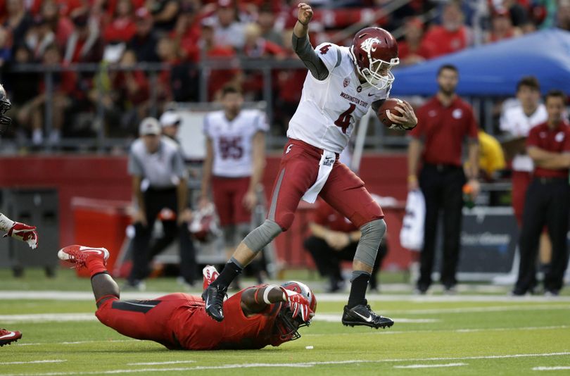 WSU quarterback Luke Falk evades Rutgers defensive lineman Quanzell Lambert to scramble for yardage late in the second half. (Associated Press)