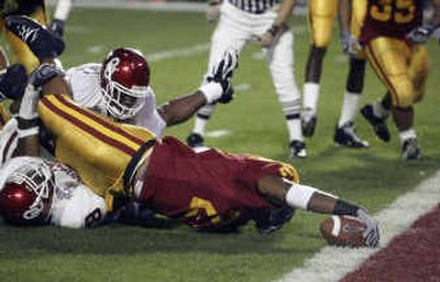 
Southern Cal's LenDale White reaches over the goal line for a 6-yard touchdown following Mark Bradley's ill-advised attempt at a punt return. 
 (Associated Press / The Spokesman-Review)