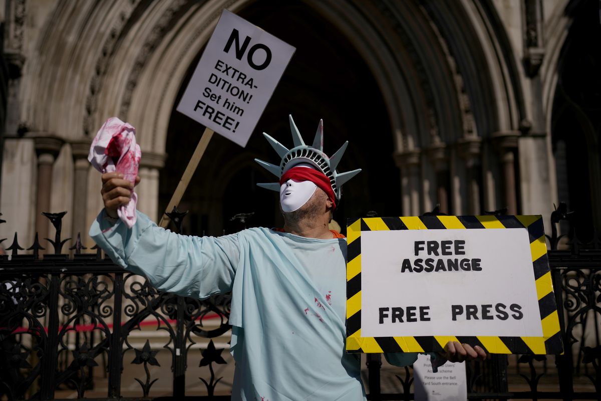 A supporter of WikiLeaks founder Julian Assange demonstrates dressed as the Statue of Liberty, during the first hearing in the Julian Assange extradition appeal, at the High Court in London, Wednesday, Aug. 11, 2021. Britain
