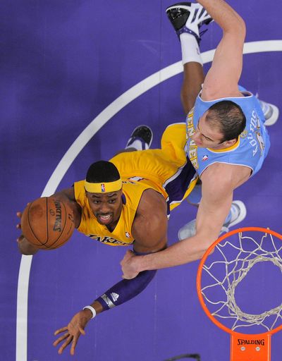 Lakers’ Dwight Howard fights off Nuggets center Kosta Koufos. Howard had 28 points, including his second career 3-pointer. (Associated Press)