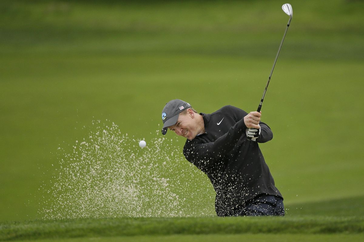 Peyton Manning hits the ball out of a bunker onto the first green of the Monterey Peninsula Country Club Shore Course during the first round of the AT&T Pebble Beach National Pro-Am golf tournament Thursday, Feb. 9, 2017, in Pebble Beach, Calif. (Eric Risberg / Associated Press)
