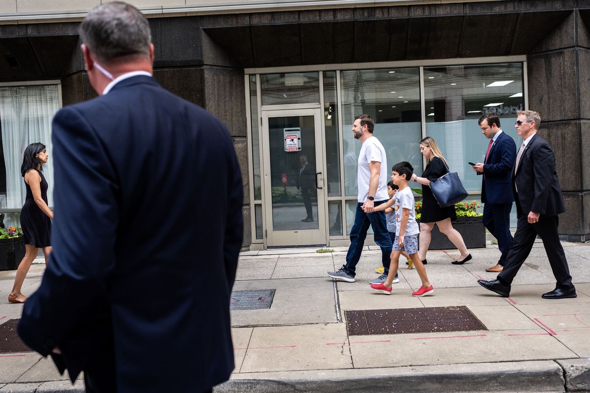 Republican vice-presidential nominee Sen. J.D. Vance walks toward his wife, Usha Chilukuri Vance, with their two children, along a street in Milwaukee, surrounded by Secret Service agents. MUST CREDIT: Melina Mara/The Washington Post  (Melina Mara/The Washington Post)