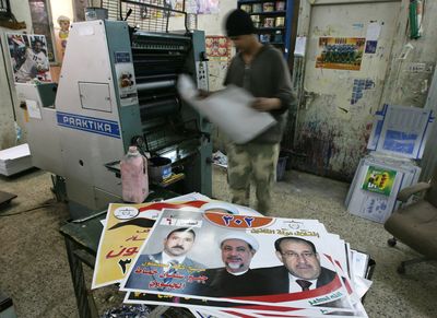 A printer examines campaign posters for  candidates in Iraq’s upcoming provincial elections at a shop in central Baghdad on Sunday. Iraq’s electoral commission says it is investigating allegations that nearly 60 candidates for Jan. 31  elections have submitted fraudulent qualification certificates.  (Associated Press / The Spokesman-Review)