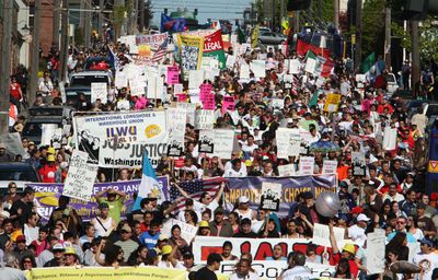 Participants walk down South Jackson Street during a May Day march through downtown Seattle on Friday.  (Associated Press / The Spokesman-Review)