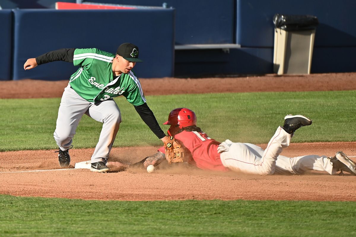 Indians outfielder Niko Decolati, right, slides safely into third base against Eugene’s Sean Roby during a High-A West game Sunday at Avista Stadium in Spokane.  (James Snook/For The Spokesman-Review)