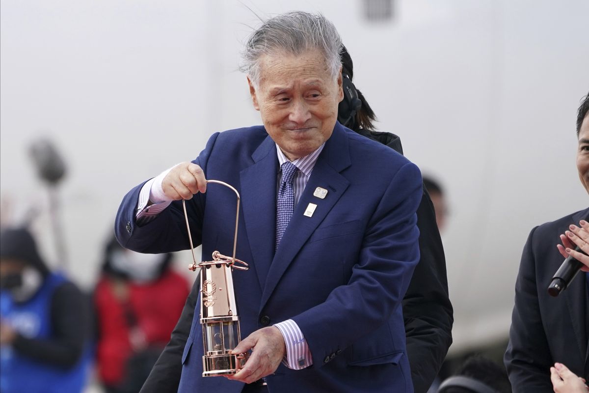 FILE - In this March 20, 2020, file photo, Tokyo 2020 Olympics chief Yoshiro Mori carries the Olympic flame during the Flame Arrival Ceremony at Japan Air Self-Defense Force Matsushima Base in Higashimatsushima in Miyagi Prefecture, north of Tokyo. Mori resigned Friday, Feb. 12, 2021 as the president of the Tokyo Olympic organizing committee following sexist comments implying women talk too much. (Eugene Hoshiko)