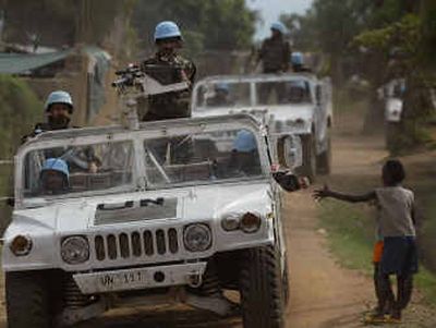 
A U.N. patrol drives past two boys in the streets of Bunia, Democratic Republic of Congo, on March 7. 
 (Associated Press / The Spokesman-Review)
