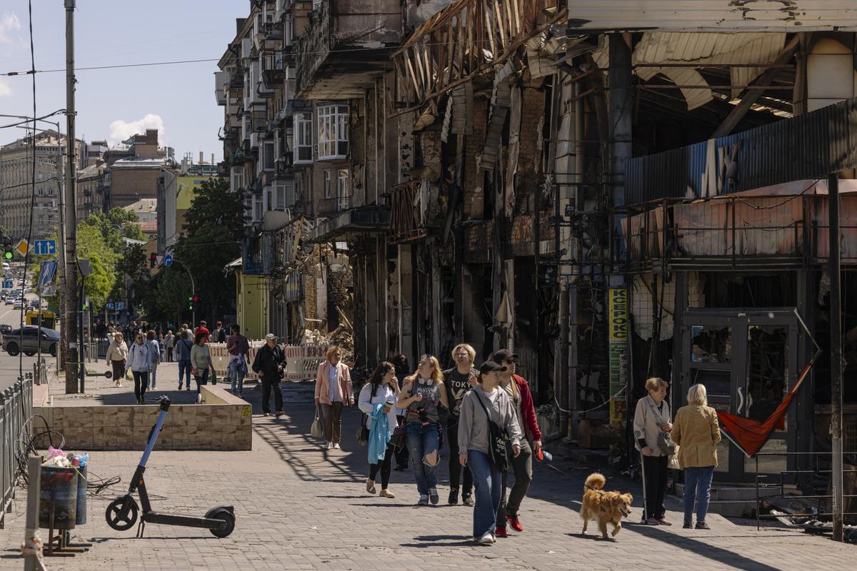 People walk past burned storefronts in the historic Lukianivskyi Market, a fixture since the 1880s.   (Serhiy Morgunov/For The Washington Post)