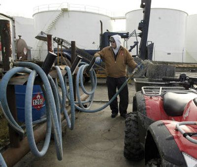 
Ron Hunnicutt, of Crowley Marine Service, fills a 55-gallon drum with heating oil last week at Crowley's terminal in Kotzebue, Alaska. Kotzebue is one of about 150 Alaska Native villages that have accepted money for heating oil from the Venezuela's Texas-based oil subsidiary Citgo. 
 (Associated Press / The Spokesman-Review)
