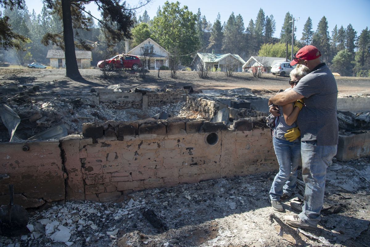 Shawn Thornton hugs his wife, Shannon Thornton, next to the rubble of their burned home Tuesday, Sept. 8, 2020 in Malden, Washington the day after a fast-moving wildfire swept through the tiny town west of Rosalia. Shawn and Shannon weren’t home at the time, but their son Cody was and managed to get their dog and a few belongings before leaving just minutes before the flames swept through.  (Jesse Tinsley/The Spokesman-Review)