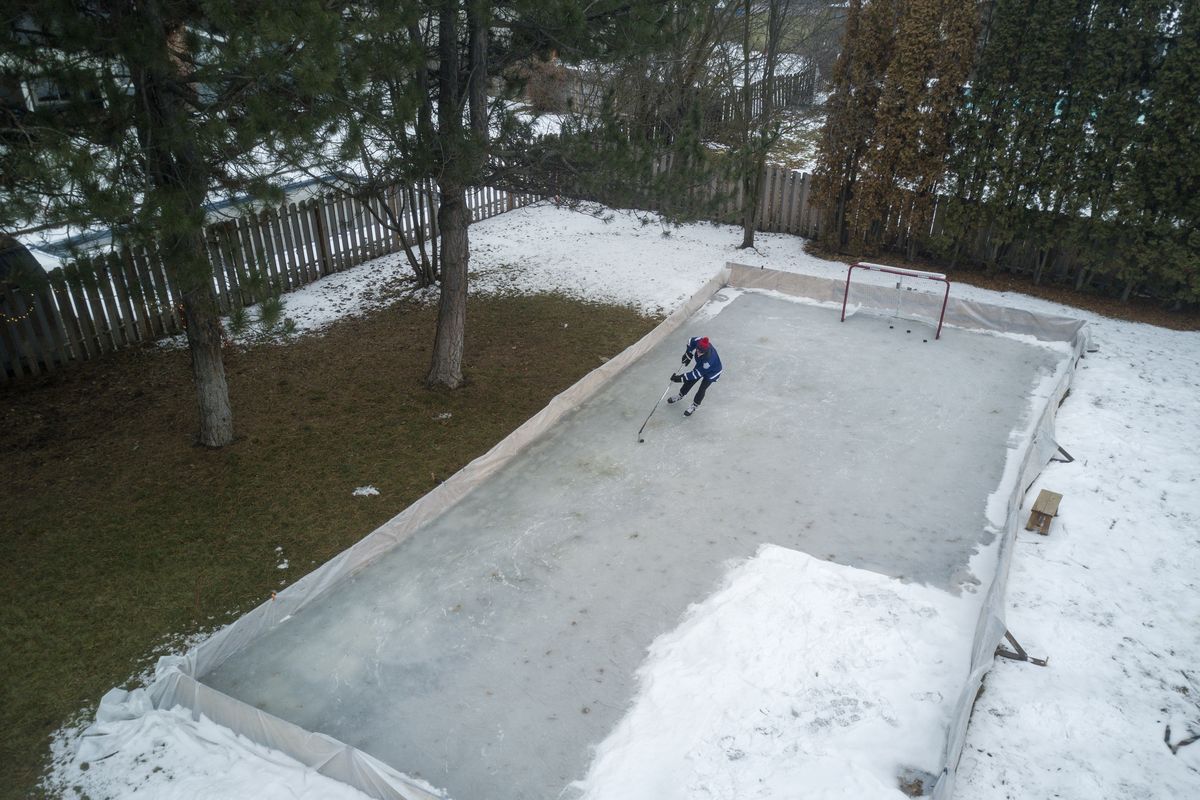 Caleb Hoogendam, 18, skates around his the makeshift hockey rink in his backyard in the Mead area Thursday, Jan. 28, 2021. The rink was fashioned from plywood and plastic sheeting. The ice was melting as he skated and he thought it might be the last day for using the rink.  (Jesse Tinsley/The Spokesman-Review)