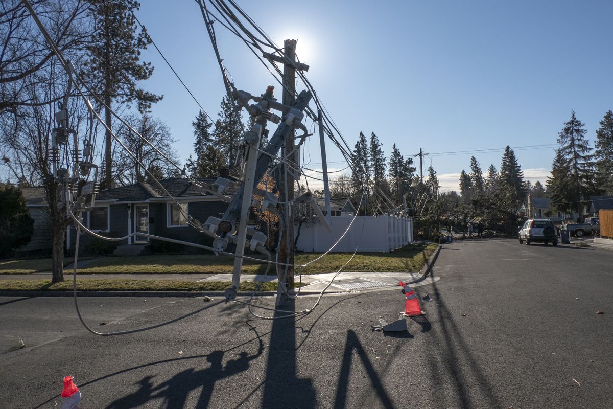 Damaged electrical poles and lines dangle after two trees that fell a block south of Arthur Street near 37th Avenue because of strong winds in the overnight hours Wednesday. Winds up to 70 mph swept through Spokane and brought down hundreds of trees and knocked out power to tens of thousands of customers.  (JESSE TINSLEY)