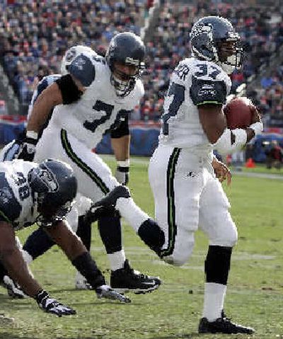
Shaun Alexander's route to 1,000-plus yards has been aided by lineman Steve Hutchinson (76). 
 (Associated Press / The Spokesman-Review)
