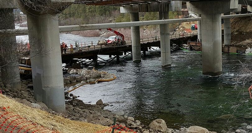 Sullivan Road bridge reconstruction -- workers maneuver on a temporary bridge on the downstream side of the main bridge in this Feb. 14, 2015, view with the river running at 20,000 cfs. (Tanner Grant)