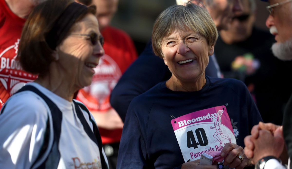 Bloomsday perennial Kris Olson-Wood, center, shares a laugh with friends before the start of the  Bloomsday Perennials Run in Spokane on Sunday. (Kathy Plonka / The Spokesman-Review)
