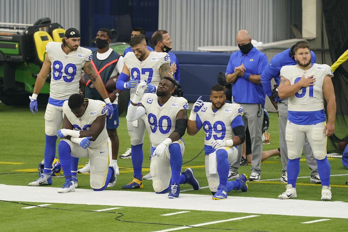 Members of the Los Angeles Rams stand and kneel during the national anthem before an NFL football game against the Dallas Cowboys Sunday, Sept. 13, 2020, in Inglewood, Calif.  (Ashley Landis)