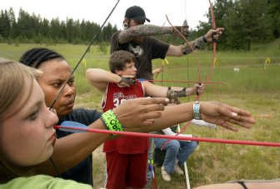 
Rebecca Erick, 27, a camp counselor at the Salvation Army's Camp Gifford, teaches archery to Destany Wegner, 13, on Wednesday. 
 (Jed Conklin / The Spokesman-Review)