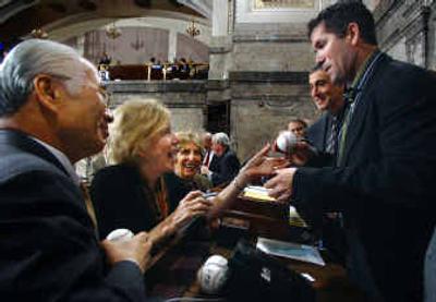 
Capitol ball fans. Retired Seattle Mariner Edgar Martinez hands an autographed baseball to Sen. Jeanne Kohl-Welles, D-Seattle, as Sens. Paull Shin, D-Mukilteo, and Rosemary McAuliffe, D-Bothell, wait for their turn to get Martinez's autograph Wednesday at the Capitol in Olympia. Lawmakers honored the former designated hitter with a resolution; he retired last year after 18 seasons in Seattle.
 (Associated Press / The Spokesman-Review)