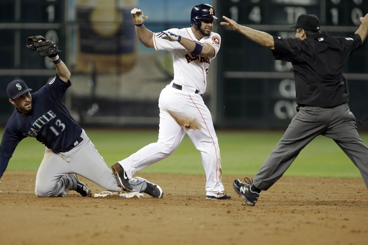 M’s second baseman Dustin Ackley shows the ball to umpire Phil Cuzzi, who signals Houston’s Fernando Martinez safe at second. (Associated Press)