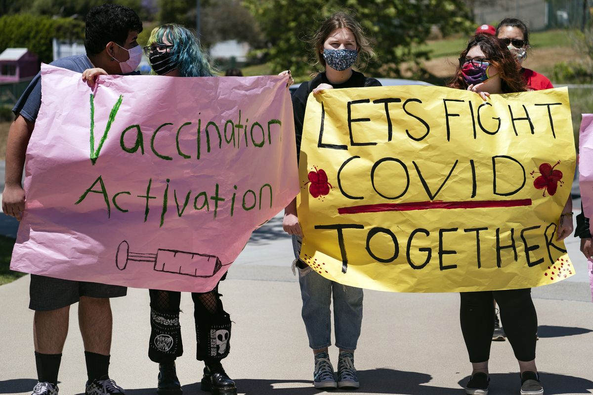 San Pedro High School students hold vaccination signs at a school-based COVID-19 vaccination event for students 12 and older in San Pedro, Calif., Monday, May 24, 2021. Schools are turning to mascots, prizes and contests to entice youth ages 12 and up to get vaccinated against the coronavirus before summer break.  (Damian Dovarganes)