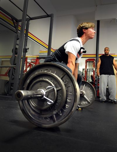 Danna Snow shows the strain of a heavy lift as her lifting partner Roland Jones watches Friday. Snow is headed to an international powerlifting competition in Miami the first week of August. (CHRISTOPHER ANDERSON / The Spokesman-Review)