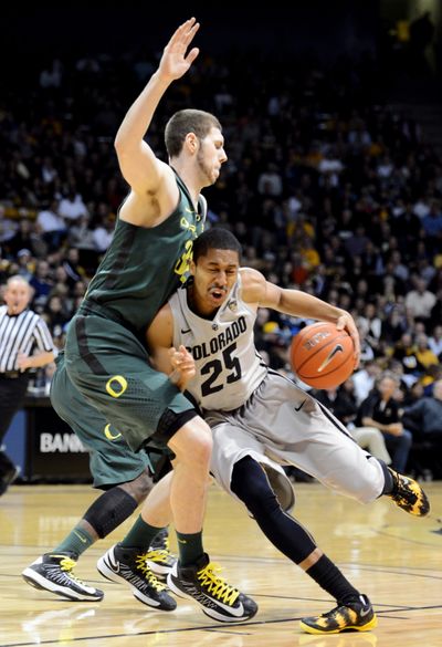 Colorado’s Spencer Dinwiddie drives on Oregon’s Ben Carter during the first half. (Associated Press)