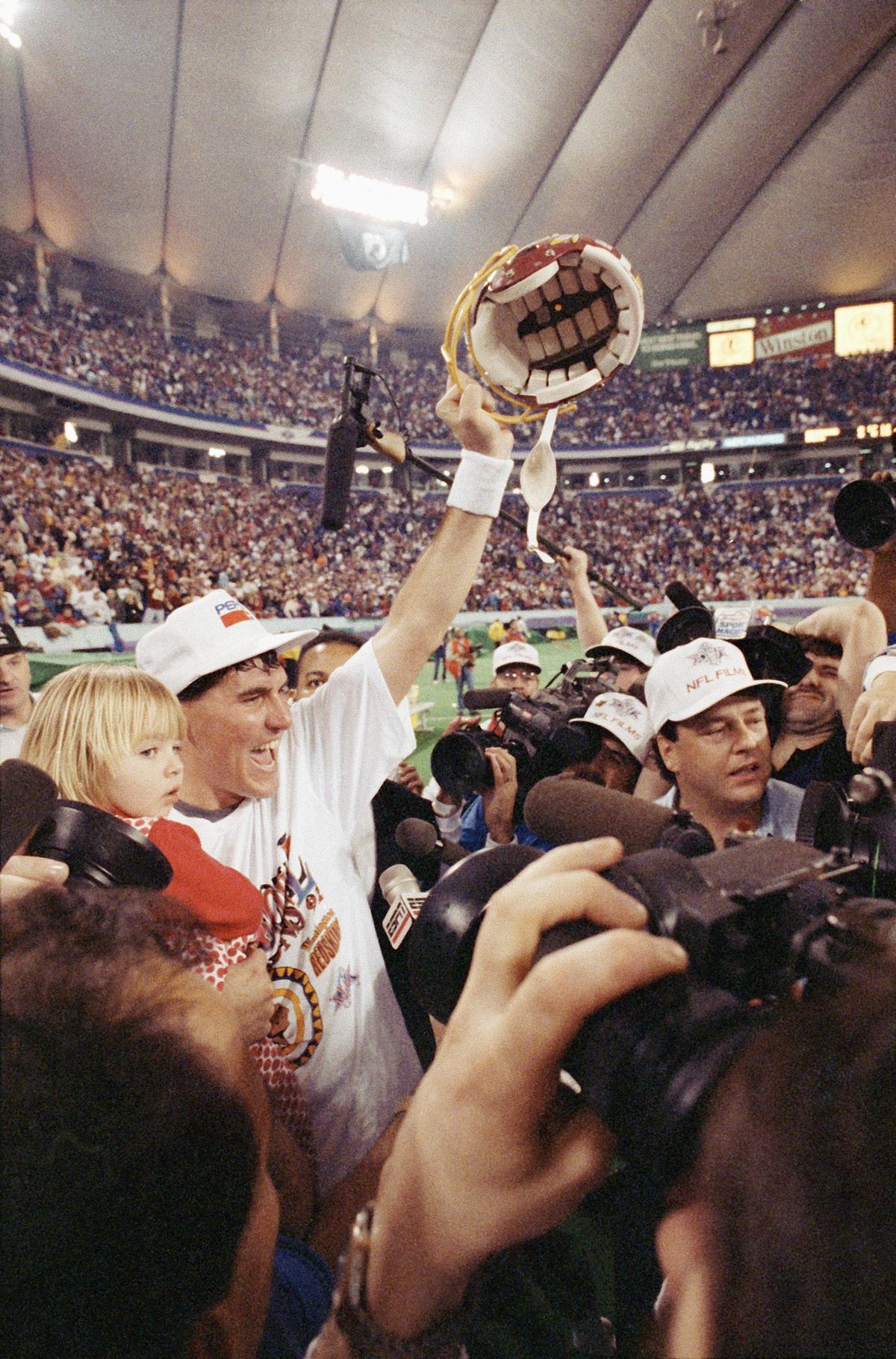 Washington quarterback Mark Rypien holds his daughter, 3-year-old Ambre, as he waves his helmet after the Redskins defeated the Buffalo Bills 37-24 to win Super Bowl XXVI in Minneapolis on Jan. 26, 1992. Rypien was named the game’s Most Valuable Player. (Jim Mone / AP)