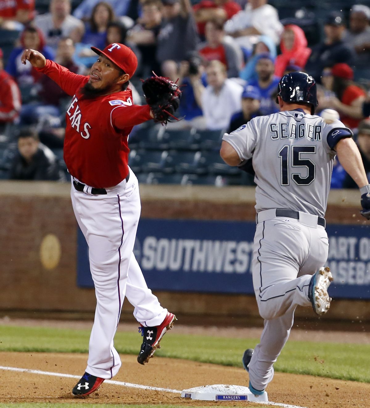 Seattle’s Kyle Seager reaches first base as Rangers starting pitcher Yovani Gallardo is unable to catch the throw from shortstop Elvis Andrus during the first inning. (Associated Press)