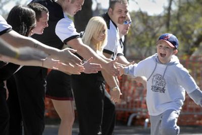 Carson Holland, of Spokane, races past the North Idaho College cheerleaders on his way to the finish of the Marmot March on Saturday at Riverfront Park. Some 275 children were expected to complete the 1.2 mile course. 
 (Dan Pelle / The Spokesman-Review)