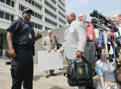 
John Hawthorne, right, husband of Olympic bombing victim Alice Hawthorne, is told he has to move farther back on the steps of the courthouse in Atlanta on Monday as he talks to the media after the sentencing hearing for Eric Rudolph. 
 (Associated Press / The Spokesman-Review)
