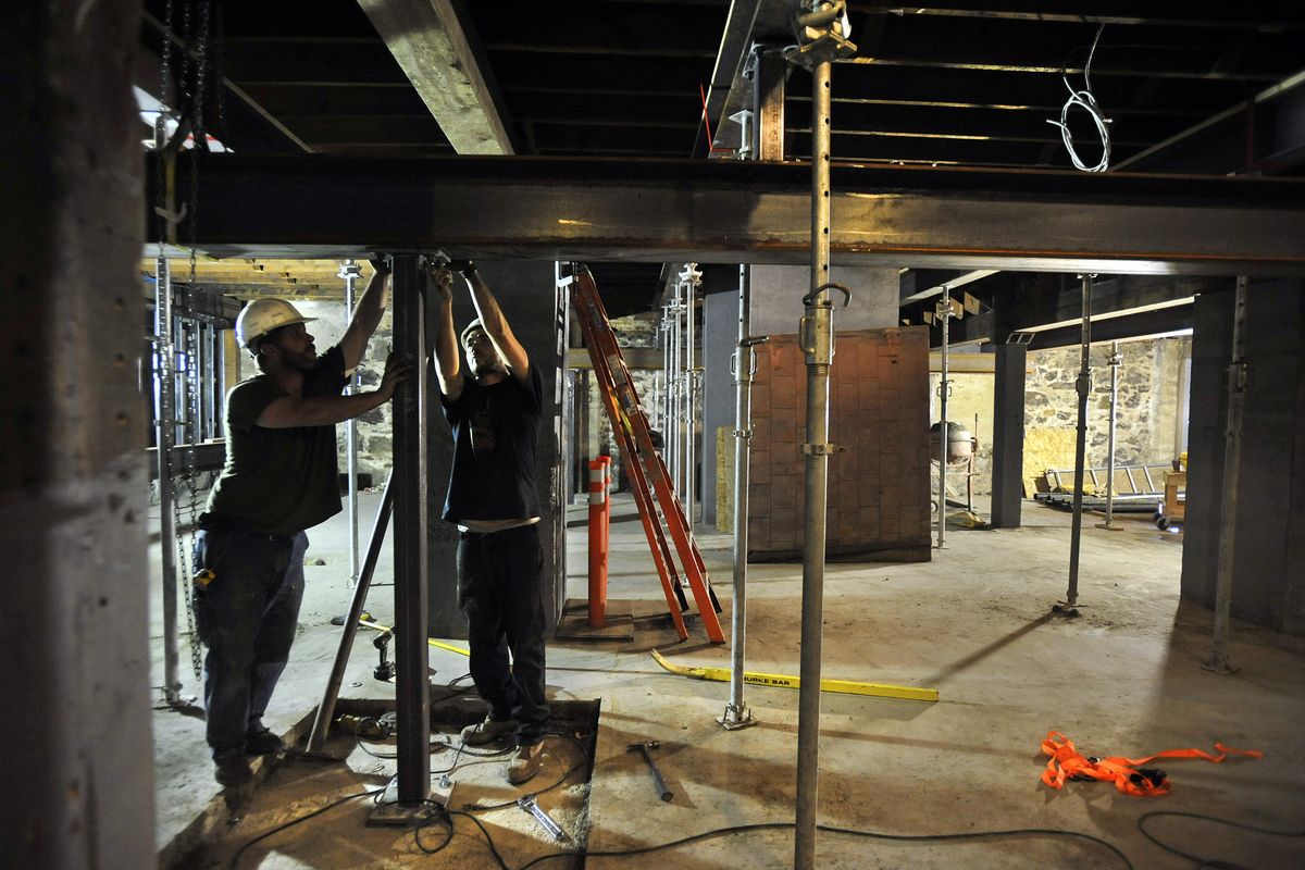 Chris Byrd and Andrew Brabank, of Mauer Construction, install I-beams along the basement ceiling of the Foresters Hall on Tuesday in Spokane. The building is undergoing renovation to become the home of a new wine production facility, tasting room, bistro and events facility. (Dan Pelle)
