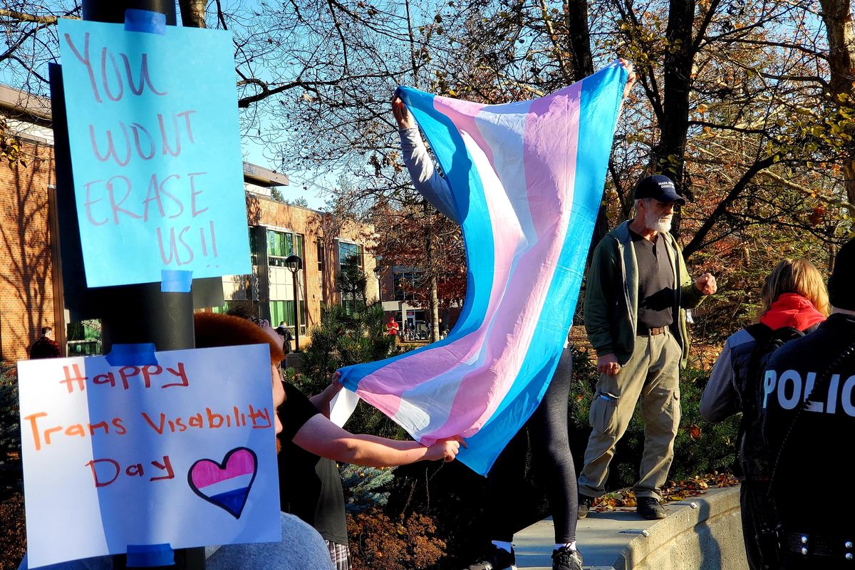 Anti-abortion activist Tom Meyer, standing at right, demonstrates on the Eastern Washington University campus in Cheney on Wednesday, Nov. 20, 2019. Students tried to block him from view and deprive him of attention by holding up a transgender pride flag. (Chad Sokol / The Spokesman-Review)