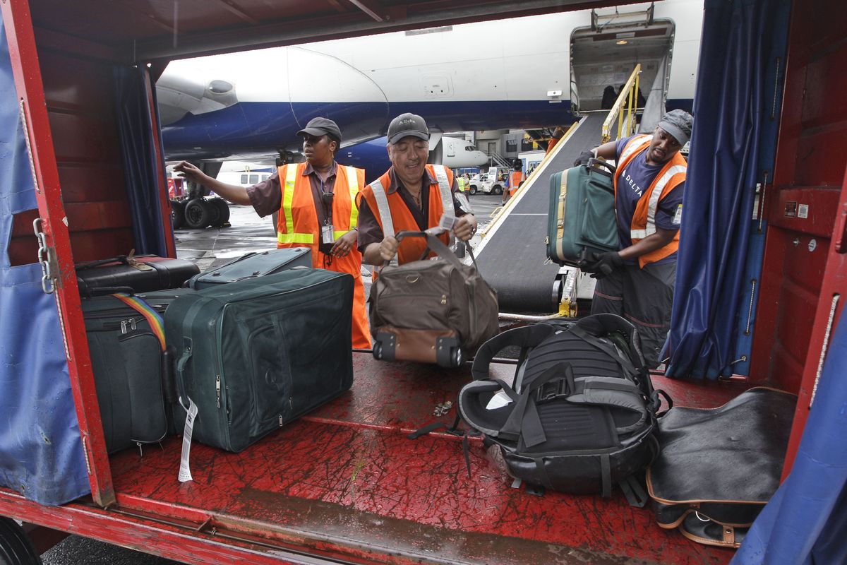 Delta Air Lines ramp agents unload bags from a flight arriving at JFK International Airport in New York. Nearly 84 percent of domestic flights arrived within 15 minutes of their schedule time in the first half of the year, the best performance since the government started tracking such data in 1988. (Associated Press)