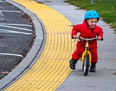 Liam Jessen, 3, blazes a colorful trail aboard his push bike at Prairie View Park on Nov. 8, 2023, in Spokane. The lad was on an outing with his nanny, Carron Axtman, and two other children.  (DAN PELLE/THE SPOKESMAN-REVIEW)