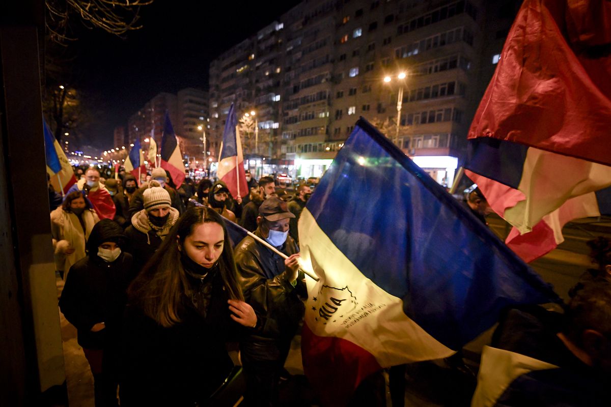 Protesters waving flags march after a deadly fire at a hospital treating COVID-19 patients in Bucharest, Romania, Saturday, Jan. 30, 2021. Hundreds marched during a protest organized by the AUR alliance demanding the resignation of several top officials, after a fire early Friday at a key hospital in Bucharest that also treats COVID-19 patients killed five people.  (Andreea Alexandru)