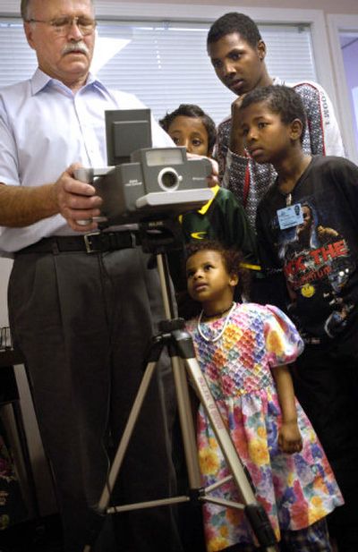 
Sixteen-year-old Salah, 12-year-old Ramadan, 10-year-old Omar and 4-year-old Faila watch as Jerry Deatherage takes photos of their siblings for greencard applications at World Relief. 
 (Holly Pickett / The Spokesman-Review)