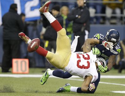 San Francisco’s LaMichael James fumbles as he is hit by Seattle Seahawks’ Ricardo Lockette  on a kickoff during the first half of the NFL football NFC championship game in Seattle. (Elaine Thompson / Associated Press)