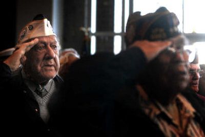 
Bill Paulukonis, 88, a Pearl Harbor survivor, salutes as 